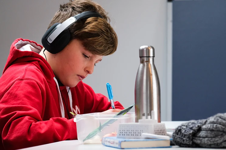 middle school student holding a device